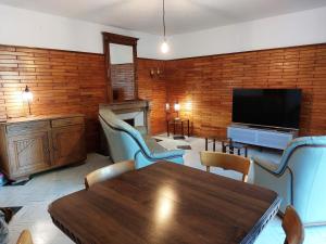 ein Wohnzimmer mit einem Tisch und einem Flachbild-TV in der Unterkunft L'ATELIER DE DESIRE in Cogna