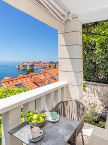 a table with a bowl of fruit on a balcony at Dubrovnik 4 Star Apartment in Dubrovnik