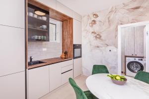 a kitchen with a white table and green chairs at Dubrovnik 4 Star Apartment in Dubrovnik