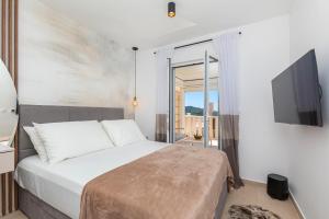 a bedroom with a bed and a tv on a wall at Dubrovnik 4 Star Apartment in Dubrovnik