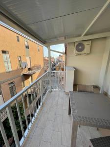 balkon ze stołem i zegarem na budynku w obiekcie Il Vicolo w mieście Marina di Schiavonea