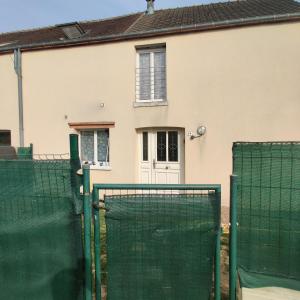 una casa bianca con un cancello e una recinzione di Maison avec Jardin avec 3 chambres a Corquilleroy