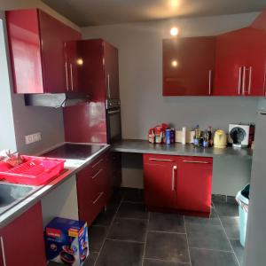 una cucina con mobili rossi e un piano di lavoro di Maison avec Jardin avec 3 chambres a Corquilleroy
