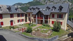 uma casa grande com um jardim em frente em Les Gentianes em Aspin-en-Lavedan