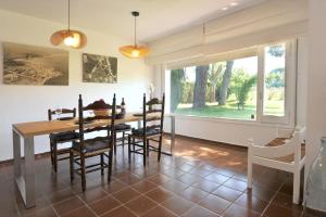 ein Esszimmer mit Tisch und Stühlen und einem Fenster in der Unterkunft ROIG in Sant Martí d’Empúries