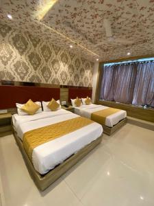 een slaapkamer met 2 bedden en een plafond met bij Hotel BKC CROWN - Near Trade Centre, Visa Consulate in Mumbai
