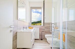 La salle de bains est pourvue d'un lavabo, de toilettes et d'une fenêtre. dans l'établissement Casa Charlie, à Arcisate