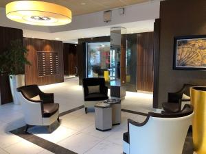 a lobby with chairs and a hair salon at Résidence Sénior Villa Sully Seynod-Annecy in Annecy