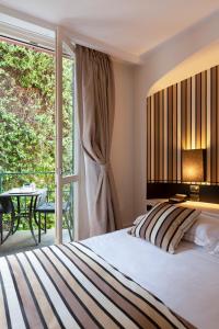 a bedroom with a bed and a balcony with a table at Eight Hotel Portofino in Portofino