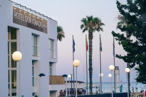 a hotel building with palm trees and the ocean at Hotel Don Ignacio in San José