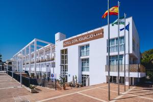 a white building with a flag in front of it at Hotel Don Ignacio in San José