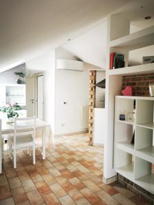 a kitchen and dining room with a table and shelves at Appartamento mansardato Civitanova Marche in Civitanova Marche