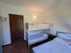 two bunk beds in a room with a door at Casa Galathee in Puntaldia