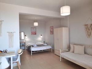 a bedroom with two beds and a couch and a table at Noemie Studios in Athanion