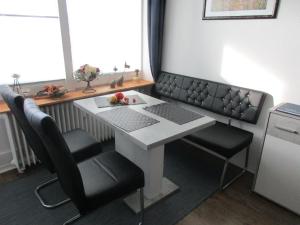 einen Tisch mit 2 Stühlen und einen Schreibtisch mit einem Laptop in der Unterkunft Ostseeferienparadies Heiligenhafen in Heiligenhafen