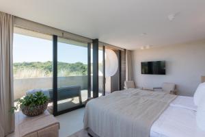 - une chambre avec un grand lit et un balcon dans l'établissement Duinhotel Tien Torens, à Zoutelande
