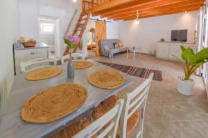 een eetkamer met een tafel en stoelen en een keuken bij Merabello Beach House in Samos