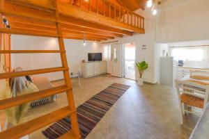 a room with a loft bed and a kitchen at Merabello Beach House in Samos