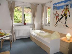 a bedroom with a bed with a painting on the wall at Hotel & Gasthaus Sterngrund in Zella-Mehlis