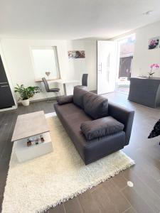 a living room with a leather couch and a table at Casa Zappata in Überlingen