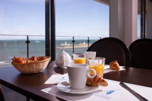 a table with a breakfast of orange juice and croissants at Hôtel Restaurant Splendid Camargue in Le Grau-du-Roi