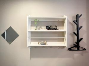 a white book shelf on a wall with a clock at 斑比Bambi in Tainan