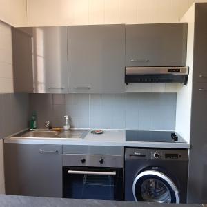 a kitchen with a washing machine and a sink at Beau séjour in Aiguebelette-le-Lac