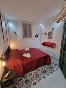 a bedroom with a red bed with two towels on it at Casa viotti Le fuoriserie in Palermo