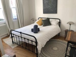 um quarto com uma cama com lençóis brancos e almofadas em Poets Rest, free parking, EV socket fees apply walk to beach em Brighton & Hove
