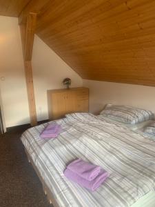 a bedroom with two beds with purple towels on them at Penzion U Orla in Petříkov