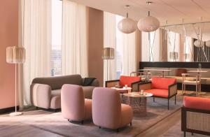 un hall avec des chaises et des tables colorées dans un bâtiment dans l'établissement OKKO Hotels Paris La Défense, à Nanterre