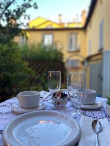 - une table avec des assiettes et des verres à vin dans l'établissement Rooftop Garden, à Bologne