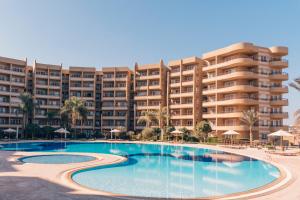 a hotel with a large swimming pool in front of a building at Grand Ocean El Sokhna in Ain Sokhna