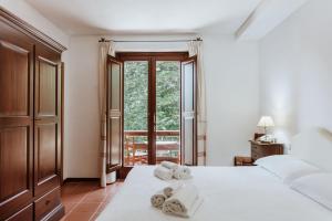 ein Schlafzimmer mit zwei Handtüchern auf einem Bett und einem Fenster in der Unterkunft Vallicciola Nature Hotel in Tempio Pausania