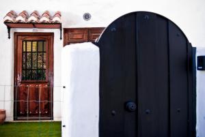 una puerta negra delante de una casa con una puerta en Las Cuevas de Monachil, en Monachil