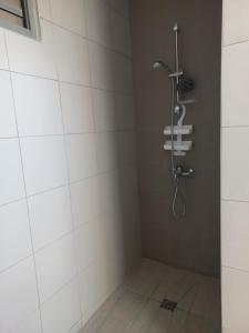 bagno con doccia e piastrelle bianche di Vaea's Place a Papeete