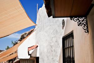 ein weißes Gebäude mit schwarzem Fenster in der Unterkunft Las Cuevas de Monachil in Monachil