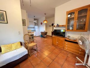 ein Wohnzimmer mit einem Sofa und einem TV in der Unterkunft Apartamento con jardín Atalaya Canet in Canet d'en Berenguer