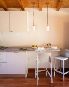 a kitchen with white cabinets and a table and chairs at La Casetta, appartamento con vista lago e montagne in San Zeno di Montagna