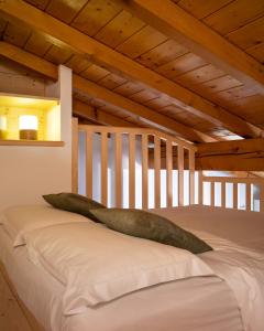a large pillow sitting on top of a bed at La Casetta, appartamento con vista lago e montagne in San Zeno di Montagna