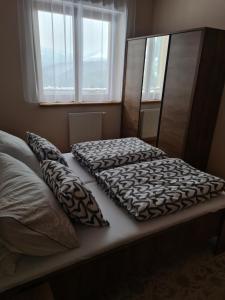 a bed with two pillows on top of it at Apartman 508 Residence in Donovaly