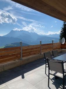 een patio met tafels en stoelen en uitzicht op de bergen bij Der Wenger in Werfenweng
