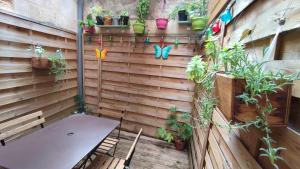 un mur en bois avec un banc et quelques plantes dans l'établissement Gite le Capucin avec parking, à Bordeaux