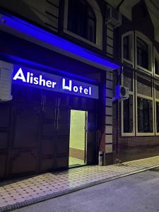 aiger hotelbord aan de voorzijde van een gebouw bij Alisher Hotel by SHOSH in Tasjkent