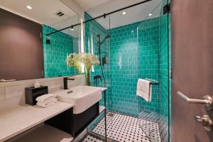 a bathroom with a sink and a shower with green tiles at J-Hotel by Dorsett in Kuala Lumpur
