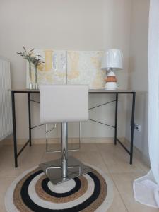 escritorio con lámpara sobre alfombra en la habitación en Grand Afroditi LUX en Pýrgos