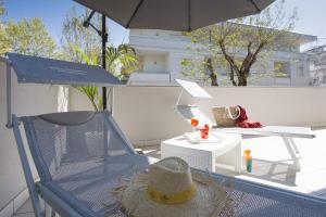 - un chapeau assis sur une chaise sur une terrasse dans l'établissement Residence Armony, à Misano Adriatico