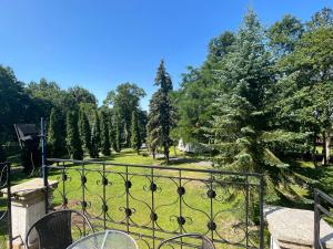 Blick auf einen Park durch ein Tor mit Bäumen in der Unterkunft Pałac Victoria in Mgowo