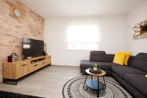 a living room with a couch and a flat screen tv at Luxury apartment Eva in Zadar