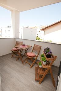 a balcony with two chairs and a table and two tables at Luxury apartment Eva in Zadar